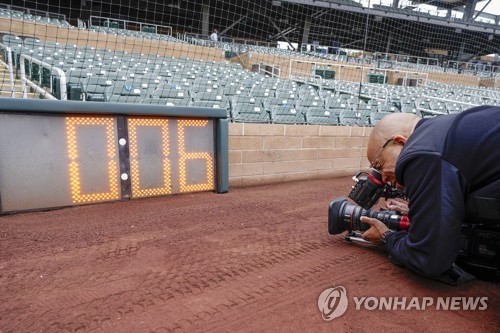 기자가 야구장에 설치된 피치 클락을 사진 찍고 있다. 메이저리그는 올해 피치 클락을 도입해 투수가 투구동작을 빠르게 가져갈 수 있도록 유도한다. [사진=AP/연합뉴스]