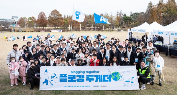 현대위아 직원 및 가족들이 11일 경기도 의왕시 왕송호수공원에서 플로깅 봉사 기념 사진을 찍고 있다. [사진=현대위아 제공]